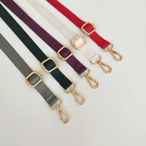 Detailed view of adjustable nylon straps in various colors with gold metal hardware