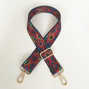 Close-up of ethnic geometric woven bag strap with golden rotating metal lobster clasps