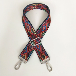 Detailed view of bohemian woven crossbody strap with red geometric pattern and silver hooks