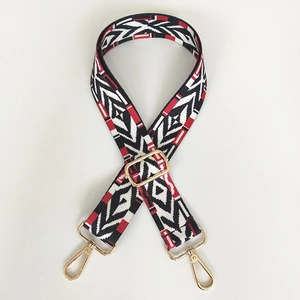 Detail of colorful geometric woven bag strap with golden lobster clasps and buckle