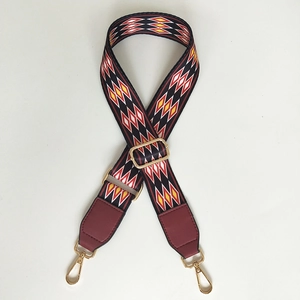 Close-up of adjustable woven shoulder strap with geometric patterns and red leather ends