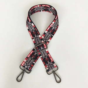 Macro detail of red and black ethnic jacquard bag strap with gunmetal metal hooks