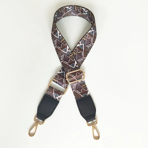 Close-up of ethnic geometric pattern bag strap with gold metal buckles and leather ends