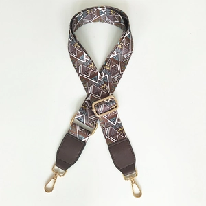 Detail of adjustable geometric woven shoulder strap with gold metal lobster clasps