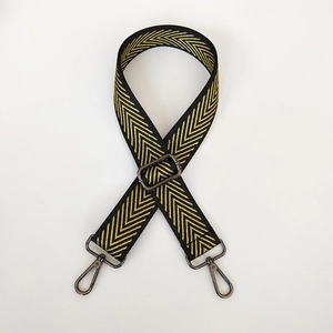 Close-up of adjustable black and gold embroidered bag strap with gunmetal lobster clasps