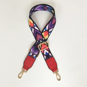 Detail of adjustable wide shoulder strap with colorful geometric pattern and gold hooks