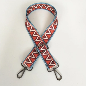 Detail of adjustable ethnic canvas strap with red and blue geometric patterns and black hooks