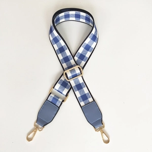Detail of adjustable blue gingham check strap with light blue leather and gold hardware