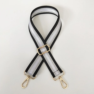 Detail of adjustable black and silver embroidery bag strap with gold metal lobster hooks