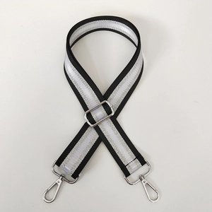 Detail view of the adjustable black and silver striped crossbody strap with metal hooks