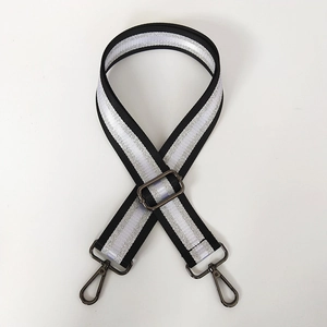 Close-up of adjustable embroidery shoulder strap with silver thread and gunmetal clasps