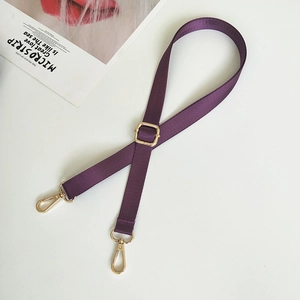 Close-up of adjustable purple nylon bag strap with gold lobster clasps and twill texture