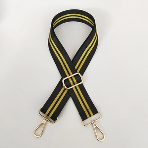 Detail of adjustable black and yellow striped bag strap with gold metal lobster clasps