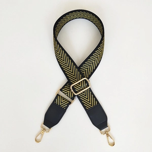 Close-up of black and gold chevron woven bag strap with adjustable metal buckles
