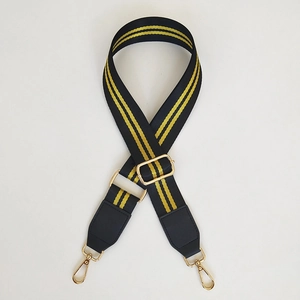 Detailed view of adjustable wide black strap with yellow stripes and gold metal hardware