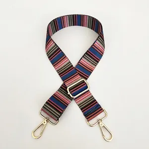 Close-up of ethnic striped woven strap with gold hardware lobster clasps and buckle