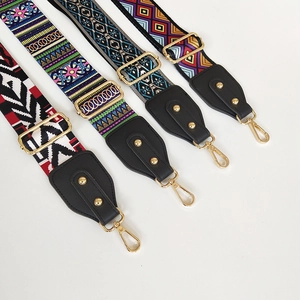 Close-up of colorful jacquard canvas bag straps with black leather ends and gold metal hooks