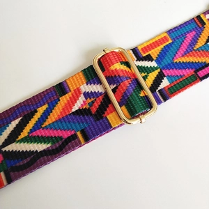 Macro view of ethnic geometric woven strap with high-gloss gold metal buckle detail
