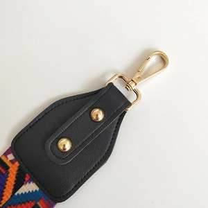 Detail of bohemian geometric woven purse strap with leather ends and golden metal clasp
