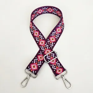 Detail view of ethnic jacquard wide strap with red and purple geometric patterns and silver hardware