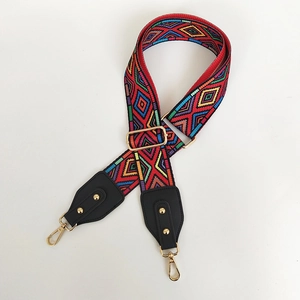 Detail of colorful geometric woven strap with gold metal hooks and black leather ends