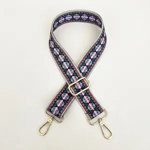 Close-up of ethnic geometric pattern strap with polished gold hardware and lobster clasp