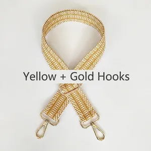 Detail of adjustable woven bag strap with yellow and white herringbone twill and gold hooks