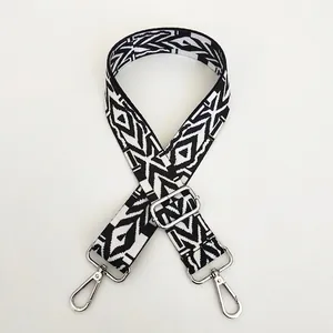 Close-up of black and white geometric woven bag strap with silver metal hardware