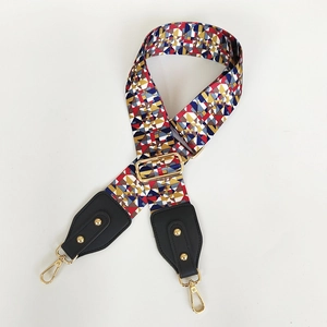 Detail of adjustable wide canvas shoulder strap with colorful geometric patterns and gold clips