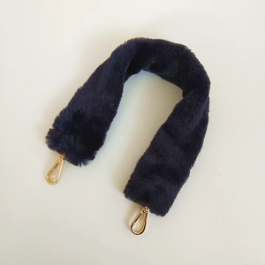 Detail of dark purple faux rabbit fur bag strap with gold metal swivel lobster clasps