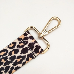 Close-up of leopard print shoulder strap with polished gold-tone metal lobster clasp