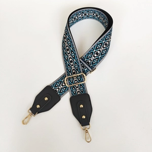 Detail of bohemian geometric woven bag strap with golden lobster clasp and buckle