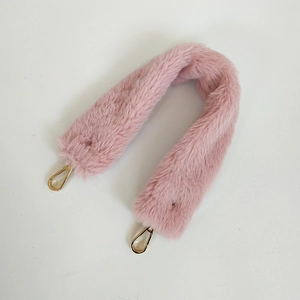 Close-up of soft light pink faux rabbit fur shoulder strap with gold metal spring hooks