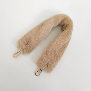 Close-up of beige faux rabbit fur bag strap with gold metal lobster clasps on ends