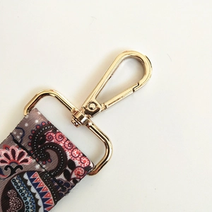 Detail of adjustable wide shoulder strap with ethnic elephant pattern and gold metal hook