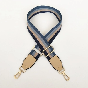 Detail van verstelbare nylon gestreepte schouderriem met goudkleurige metalen gespen
