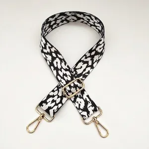 Detail view of the 3.8cm wide black and white leopard print fabric strap with gold hardware