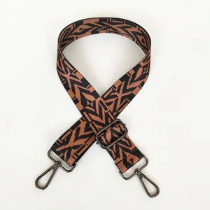 Close-up of adjustable wide canvas bag strap with geometric patterns and gunmetal swivel hooks