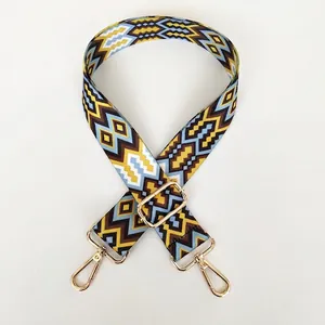 Detail of colorful geometric woven bag strap with golden metal lobster clasps