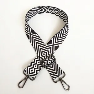 Detail of adjustable wide canvas bag strap with black and white diamond pattern