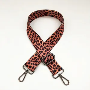 Close-up of leopard print canvas strap with gunmetal swivel hooks and adjustable buckle