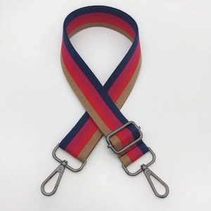 Close-up of adjustable striped handbag strap with navy blue and red webbing and gunmetal hooks