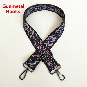 Macro detail of geometric patterned wide canvas bag strap with gunmetal trigger hooks
