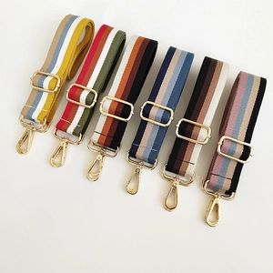 Close-up of adjustable striped nylon shoulder straps with gold-tone metal hardware clips