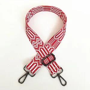 Detail of red and white geometric woven strap with gunmetal swivel hooks and adjustable buckle