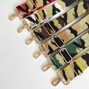 Macro shot of colorful jacquard camo bag straps with golden metallic lobster clasps