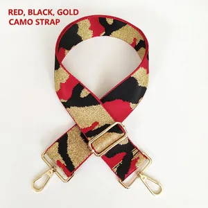 Detail of red and black jacquard camo bag strap with gold metal hooks and adjustable buckle