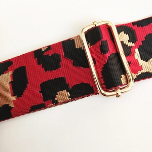 Detail of red and black leopard pattern woven strap with gold adjustable metal buckle