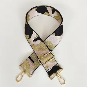 Detail of pink and gold jacquard camo strap with pale gold metal swivel hooks and buckles