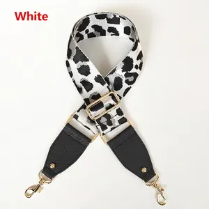Detail of leopard print bag strap with black litchi leather and gold metal buckle
